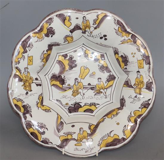 A Dutch Delft lobed flower shaped dish, late 17th century, painted in manganese and yellow (hairline crack) diameter 34cm